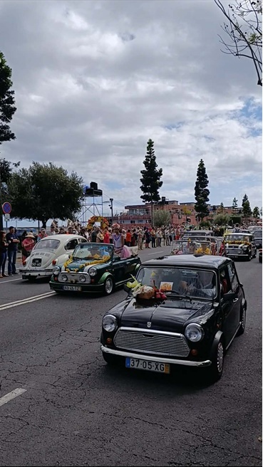Parada klasycznych samochodów Madeira Flower Classic | Festiwal Kwiatów Madera 2025 Avenida do Mar w Funchal podczas parady "Madeira Flower Classic Auto Parade". Klasyczne pojazdy ozdobione są kolorowymi kwiatami, a towarzyszą im uczestnicy w strojach z epoki i kwietnych motywach. To jedna z najpiękniejszych atrakcji Festiwalu Kwiatów na Maderze w latach 2026, 2027 i 2028