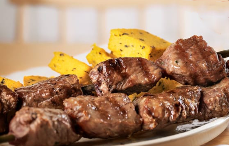 Говяжья эспетада с Мадейры на тарелке Традиционная мадейрская эспетада из говядины на тарелке, мясо на шпажке